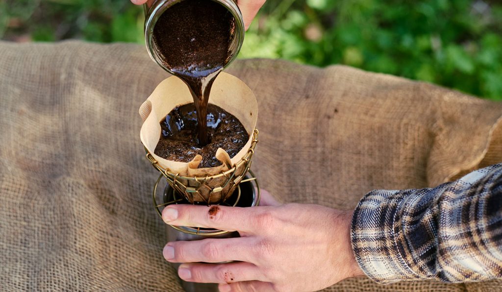 Straining the coffee grounds out of the coffee.